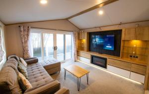 a living room with a couch and a flat screen tv at Valley 127A - Coghurst Hall in Westfield