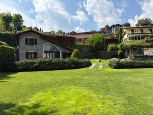 a house in a yard with a green lawn at Casetta Mary in Bellagio