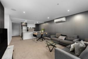 a living room with a couch and a table at The Piastri at Midnight in Braddon