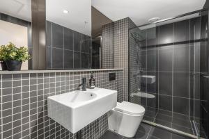 a bathroom with a sink and a toilet at The Piastri at Midnight in Braddon +7 photos