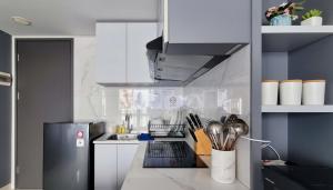a kitchen with white cabinets and a black refrigerator at 3 Bed Room One Residence by momo in Pulau Sembakau Kecil
