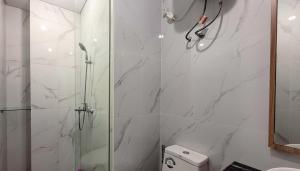a white bathroom with a shower and a toilet at 3 Bed Room One Residence by momo in Pulau Sembakau Kecil +10 photos