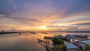 a sunset over a river with boats in it at 3 Bed Room One Residence by momo in Pulau Sembakau Kecil