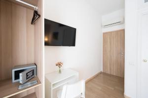 a room with a tv on a wall with a table at Panoramic Rooms Salerno in Salerno