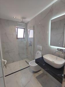 a bathroom with a sink and a toilet and a shower at Villa LeoZeka in Ksamil