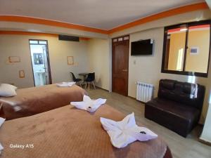 a hotel room with two beds with white flowers on them at Qamana Soto S in Uyuni