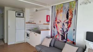 a living room with a couch and a painting on the wall at North Home in Skellefteå