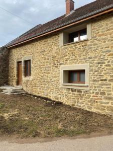 a brick house with two windows on the side of it at La petite Cocotte in Marcheseuil