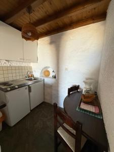 a small kitchen with a table and a sink at Villas Kalafatis Apartments in Kalafatis