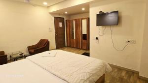 a hospital room with a bed and a flat screen tv at Hotel ShivInn in Gandhinagar