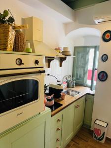 a kitchen with a microwave oven and a sink at La Maisonette de Symi in Symi