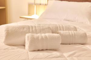 a white bed with white towels on it at Dara Holiday Apartments in Marsala +54 photos
