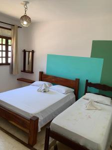 two beds sitting next to each other in a room at Pousada PauBrasil in Barra Grande