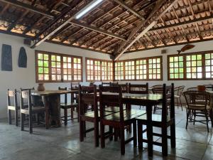 a dining room with tables and chairs and windows at Pousada PauBrasil in Barra Grande +15 photos