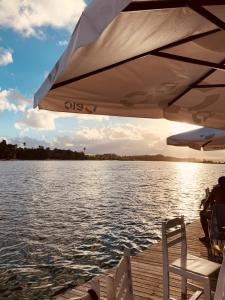 a table and chairs sitting on a dock next to the water at Pousada PauBrasil in Barra Grande