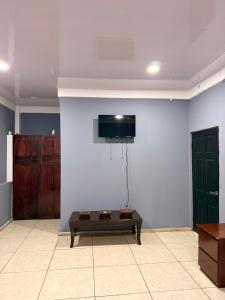 a living room with a tv on a white wall at La Casona Guest House in La Unión