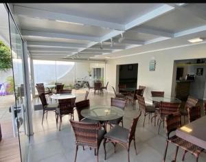 a dining room with tables and chairs and a balcony at pousada das manas in Torres +25 photos