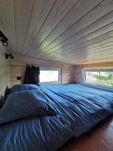 a large bed in a room with a large window at La Tiny des Prés in LʼAbsie