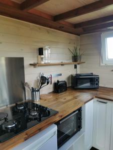 a kitchen with a stove and a microwave at La Tiny des Prés in LʼAbsie