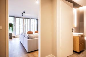 a living room with a white couch and a window at Stylische Penthouse - Maisonette - Wohnung im edlem Design mit Balkon, Dachterrasse und kostenloser Tiefgarage im Herzen von Markkleeberg - Neuseenland in Markkleeberg
