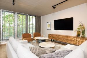 a living room with white furniture and a flat screen tv at Stylische Penthouse - Maisonette - Wohnung im edlem Design mit Balkon, Dachterrasse und kostenloser Tiefgarage im Herzen von Markkleeberg - Neuseenland in Markkleeberg