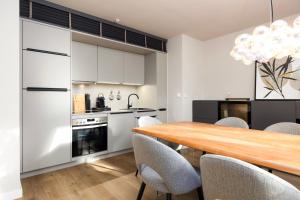 a kitchen and dining room with a wooden table and chairs at Stylische Penthouse - Maisonette - Wohnung im edlem Design mit Balkon, Dachterrasse und kostenloser Tiefgarage im Herzen von Markkleeberg - Neuseenland in Markkleeberg +27 photos