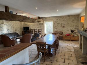 a living room with a wooden table and chairs at La Chaume en Loire in Devay