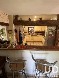 a kitchen with two chairs and a counter and a refrigerator at La Chaume en Loire in Devay