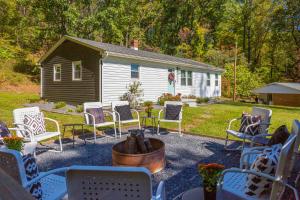 a group of chairs sitting on a patio with a house at Memes Cottage Near Nelson 151 in Afton