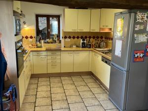 a kitchen with yellow cabinets and a refrigerator at La Chaume en Loire in Devay +23 photos