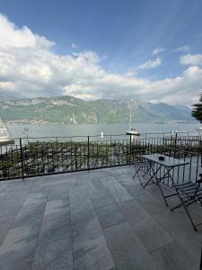a patio with a table and chairs overlooking the water at Locanda La Pergola in Bellagio