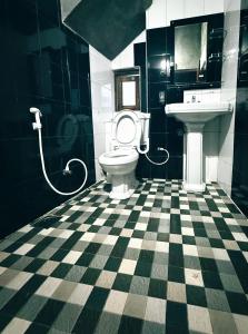 a black and white bathroom with a toilet and sink at Roshan Guest House in Nuwara Eliya