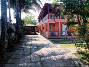 a house with palm trees in front of it at Casa de temporada em Araruama in Araruama