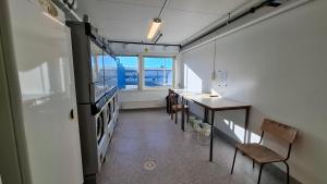 a room with a kitchen with a table and a refrigerator at North Home in Skellefteå