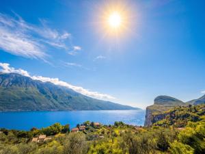 a lake in the mountains with the sun in the sky at Casa borgo Arias Lake View in Tremosine Sul Garda