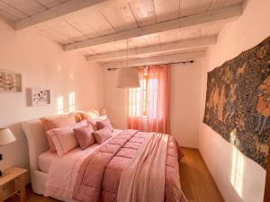 a bedroom with a bed with pink blankets and a window at Casa borgo Arias Lake View in Tremosine Sul Garda