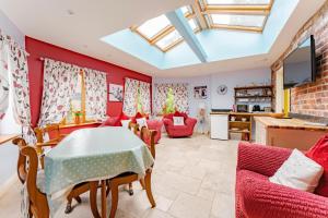 a living room with red walls and a table and chairs at Roundabout Farm in Thurning