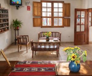 a living room with a couch and a table with flowers at Hotel La Casona in Pisco