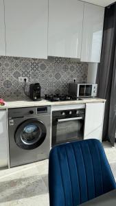 a kitchen with a stove and a washing machine at Kevin Island House in Ilhéu de Santa Maria