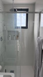 a bathroom with a shower with a glass door at Kevin Island House in Ilhéu de Santa Maria