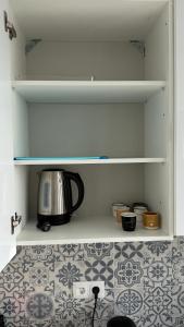a tea kettle on a shelf in a kitchen at Kevin Island House in Ilhéu de Santa Maria +26 photos