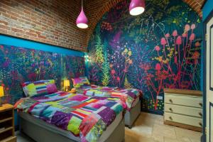 a bedroom with a bed and a wall with flowers at Roundabout Farm in Thurning