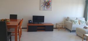 a living room with a couch and a table with a tv at Penthouse with panoramic view in Vilamoura