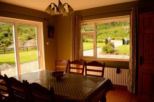 a dining room with a table and a large window at Black Valley lodge in Killarney
