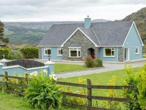a blue house with a fence in a yard at Black Valley lodge in Killarney