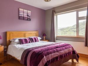 a bedroom with a bed with purple walls and a window at Black Valley lodge in Killarney +24 photos