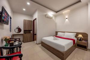 a hotel room with a bed and a table and a chair at Hotel Trung Mai-Sân Bay in Ho Chi Minh City