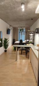 a living room with a table and a bedroom at Petit BANFIELD in Banfield