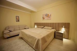 a bedroom with a bed and a couch at Dedi Apartment 1 in Shkodër