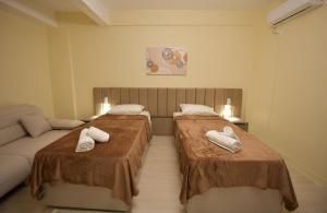 two beds in a small room with a couch at Dedi Apartment 1 in Shkodër